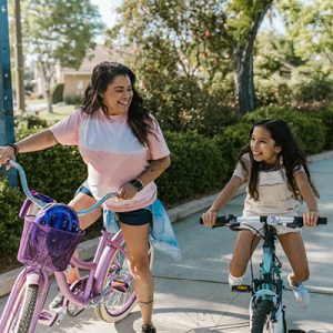 mother and daughter biking together in the summer